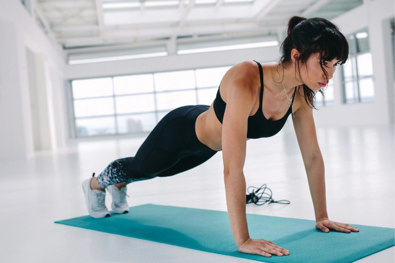 benefits of strength training, woman performing a push up